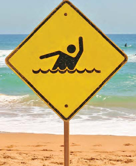 A yellow beach sign stands in the sand, indicating safety or warning information provided by a sign posts supplier in Perth